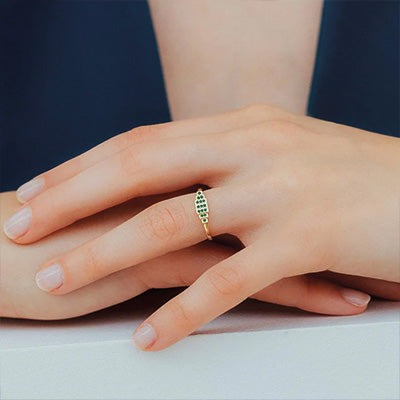 Emerald engagement ring worn on the ring finger