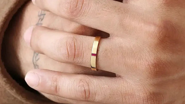 Agni men's engagement ring in 18K yellow gold set with a baguette-cut ruby, worn on the ring finger