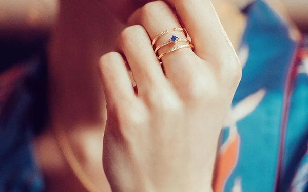 Blue sapphire and diamond ring in 18K yellow gold worn on the hand by Mayuri