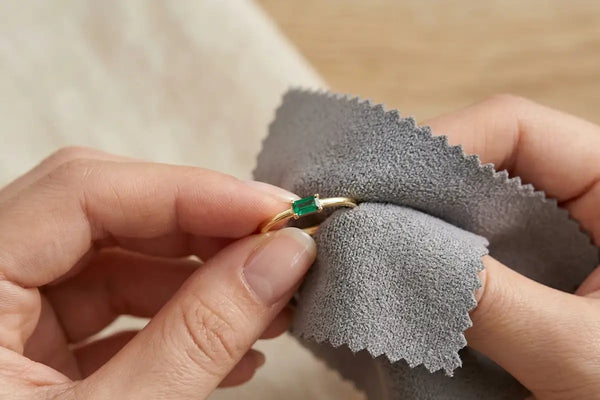18K yellow gold ring set with an emerald, gently cleaned with a soft grey microfibre cloth