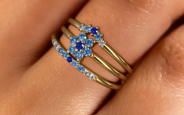 Anaya, Surya and Kiran rings in 18K yellow gold with a Horizon gradient of blue sapphires, worn on the finger by Mayuri
