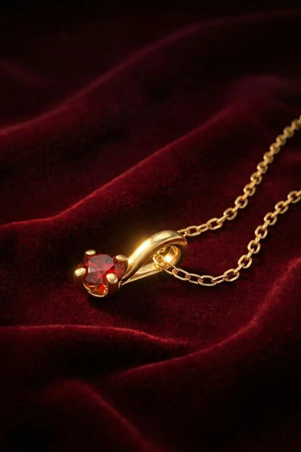 Ruby pendant in 18K yellow gold, claw setting, on red velvet, with a fine gold chain