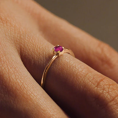 Ruby engagement ring in gold worn on a feminine hand