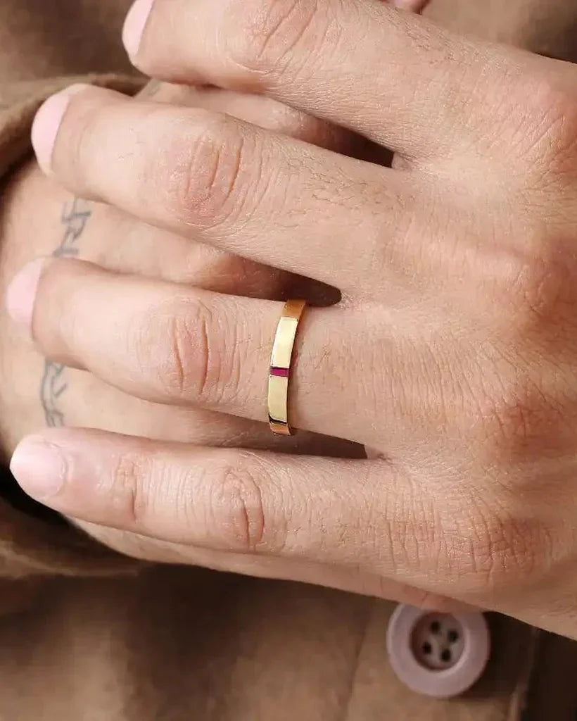Agni men's engagement ring in 18K yellow gold set with a baguette-cut ruby, worn on the ring finger
