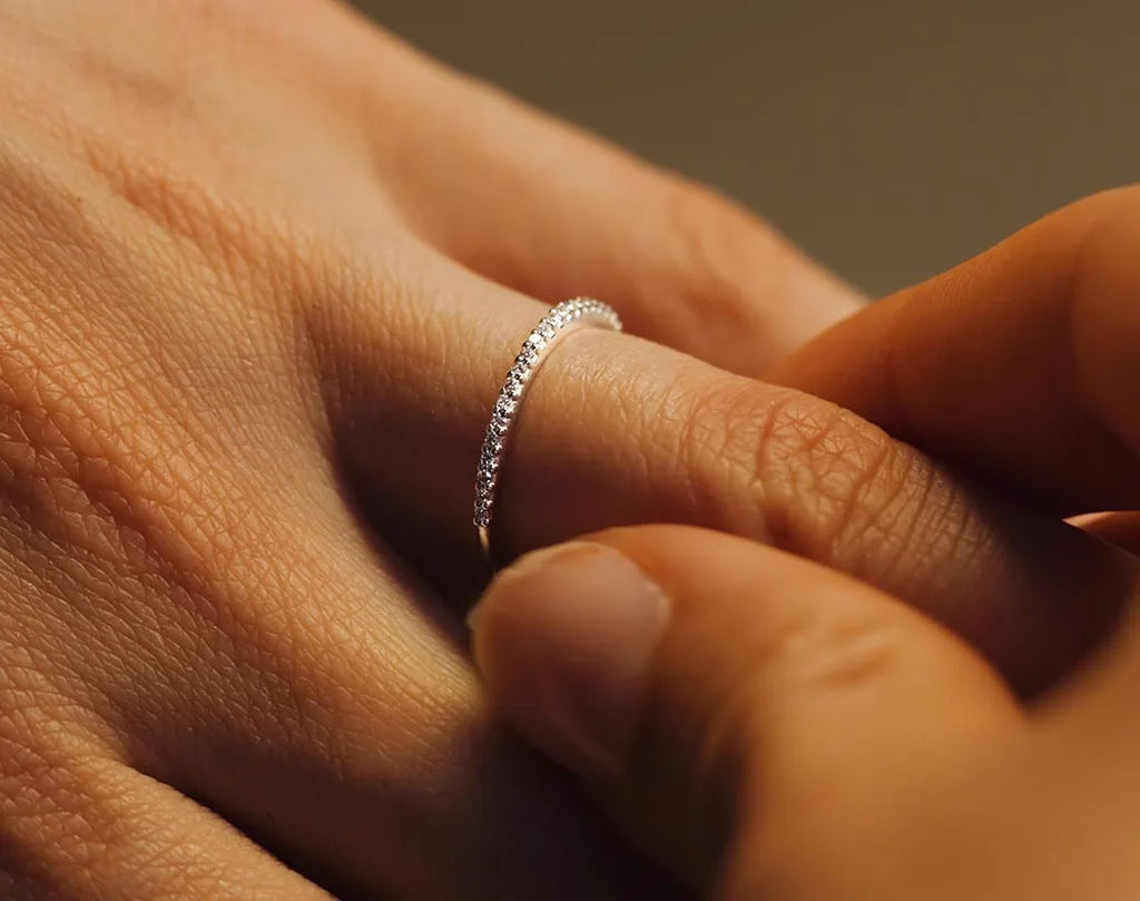 A fine diamond pavé wedding ring in 18K white gold worn on the finger, a symbol of commitment by Mayuri