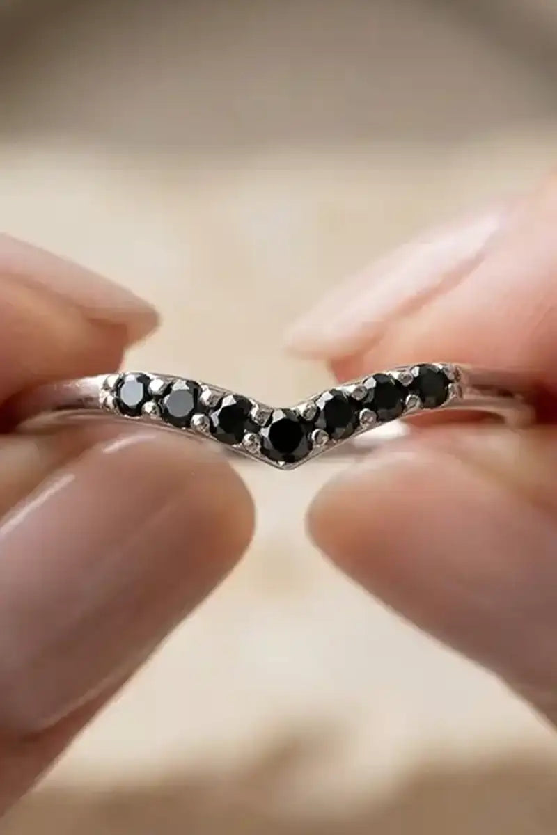 Solitaire black diamond engagement ring in 18K white gold, feminine hand, natural light