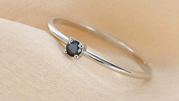 Saral ring set with a black diamond, worn on the finger