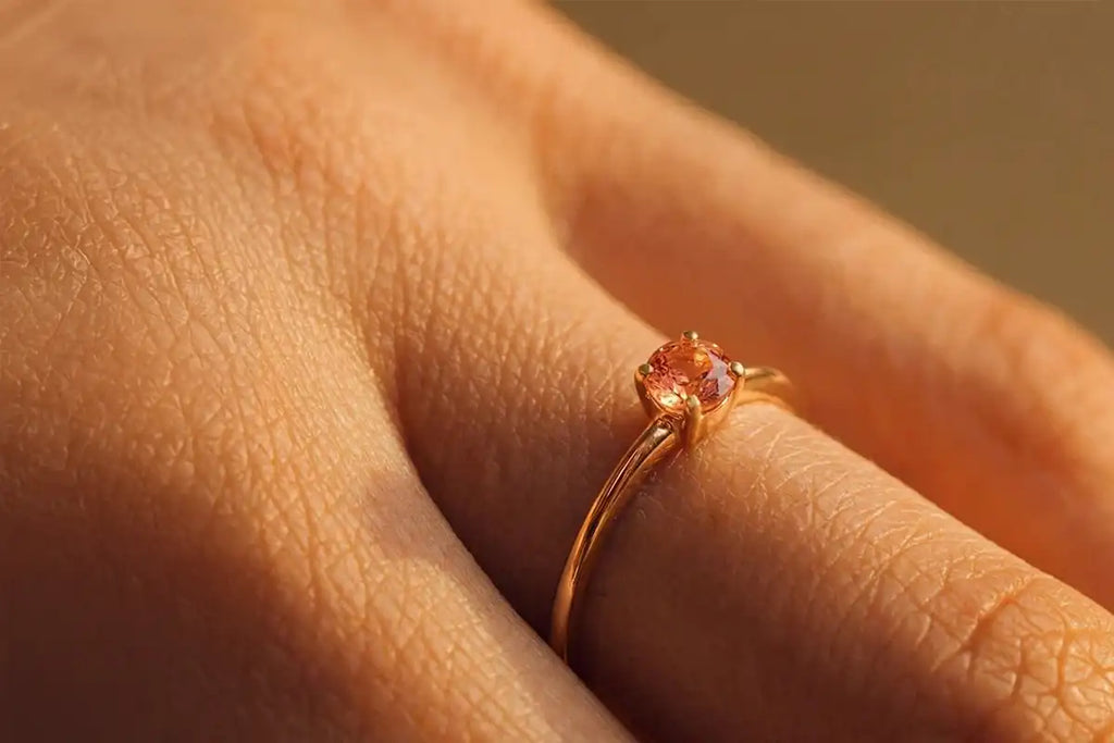 Mayuri jewel featuring a natural orange sapphire, with warm tones evoking the padparadscha colour