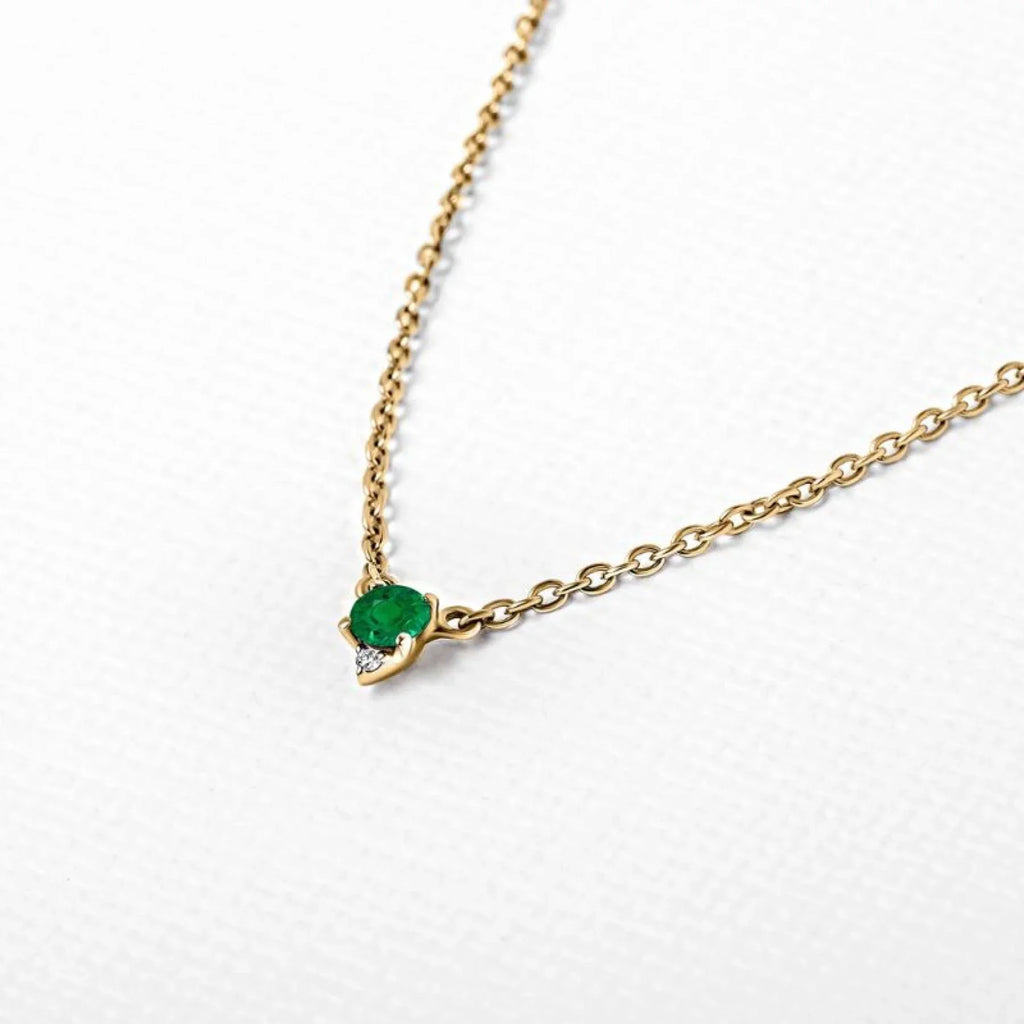 A yellow gold and emerald pendant necklace, at the ideal length to balance facial proportions