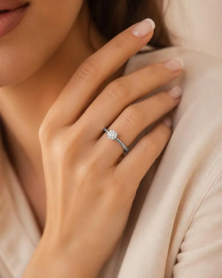 Solitaire diamond engagement ring in white gold worn on an elegant feminine hand
