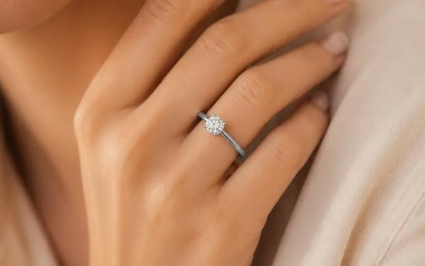Solitaire diamond engagement ring in white gold worn on an elegant feminine hand