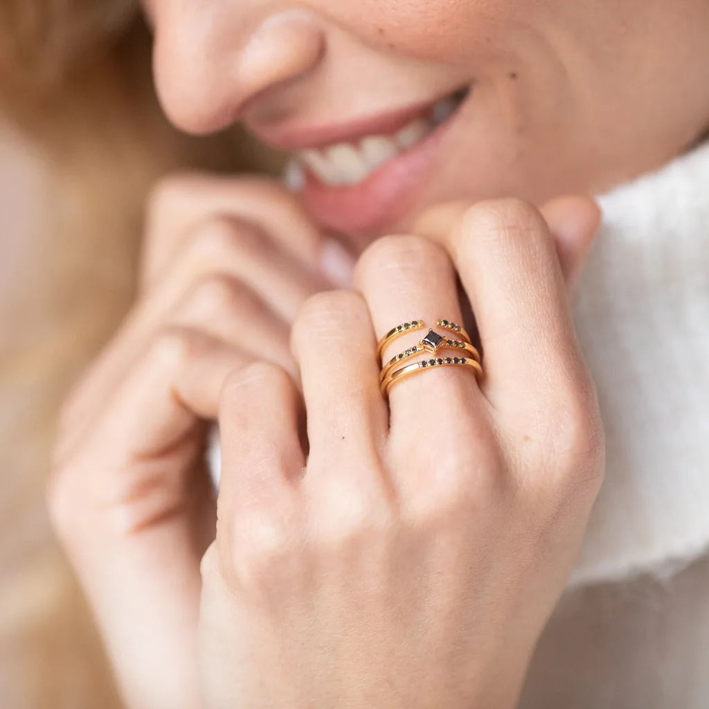 Mayuri stackable rings in yellow gold and white gold, set with black diamonds, worn together on the finger