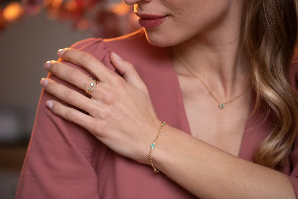 The Indrani necklace, Dhanya bracelet, and rings in 18K yellow gold with emeralds by Mayuri