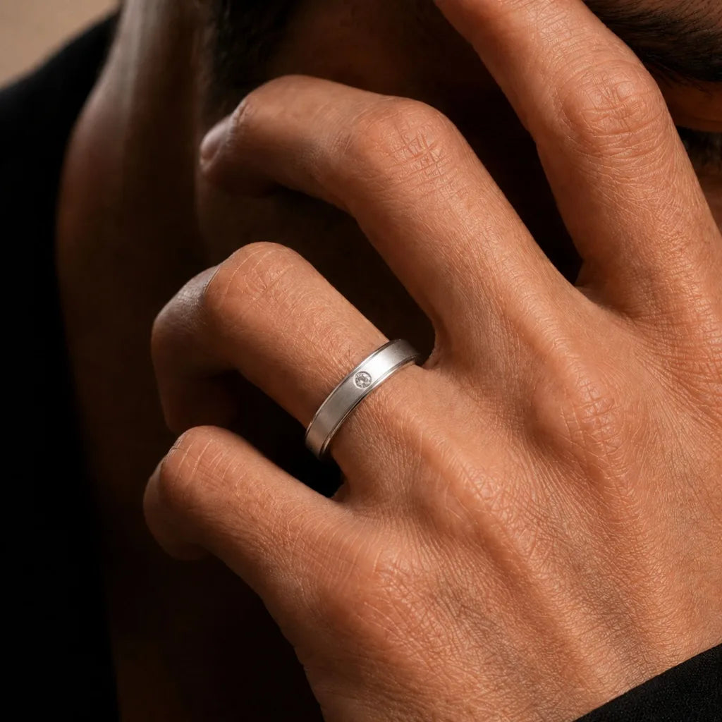 18K white gold band ring set with a diamond, worn on the finger, by Mayuri