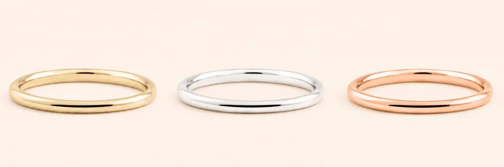 Three identical half-round wedding bands in 18K yellow gold, white gold and rose gold, side by side