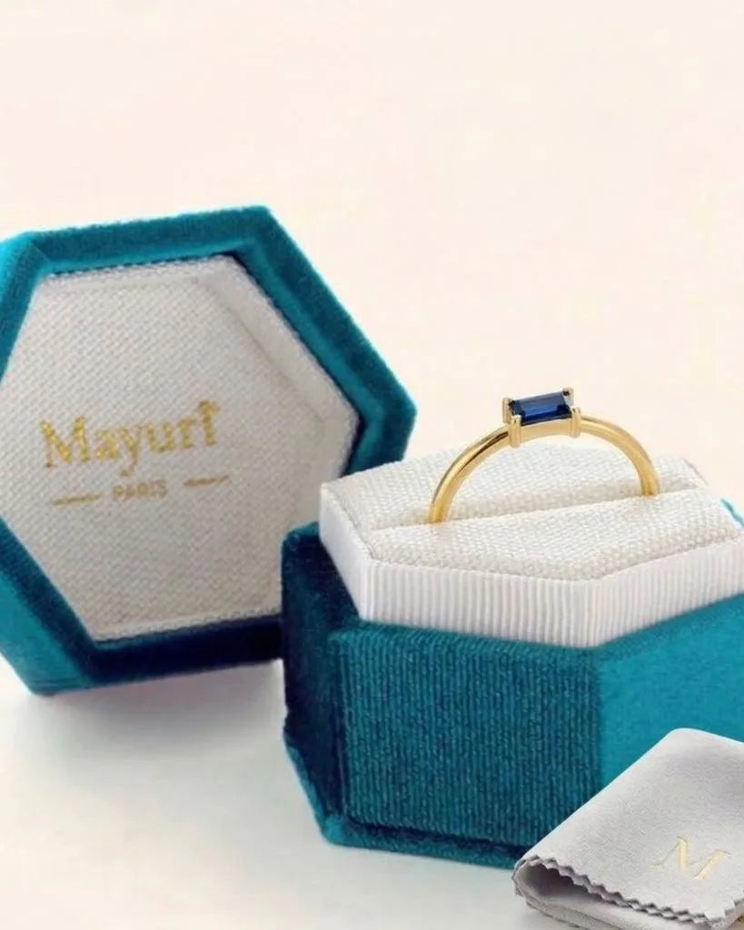Sapphire ring in yellow gold in its Mayuri velvet case, beside the polishing cloth