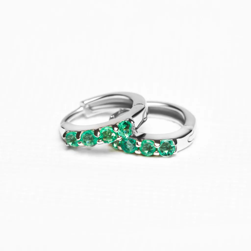 Sumitra hoops in 925 silver set with emeralds, close-up view of visible prongs