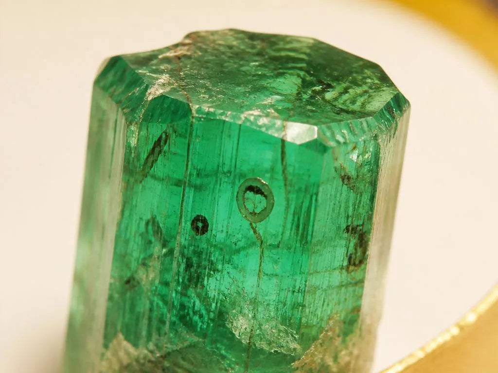 Raw emerald crystal revealing its natural inclusions and the stone's characteristic jardin