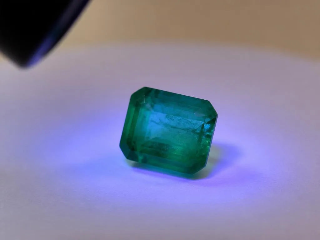 Natural emerald under a 365 nm ultraviolet lamp showing faint fluorescence, a gemmological test