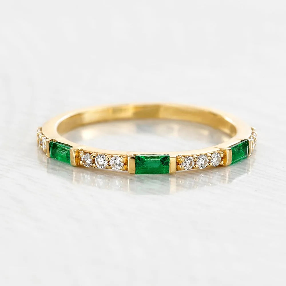Moksha wedding ring in 18K yellow gold set with baguette cut emeralds and diamonds by Mayuri