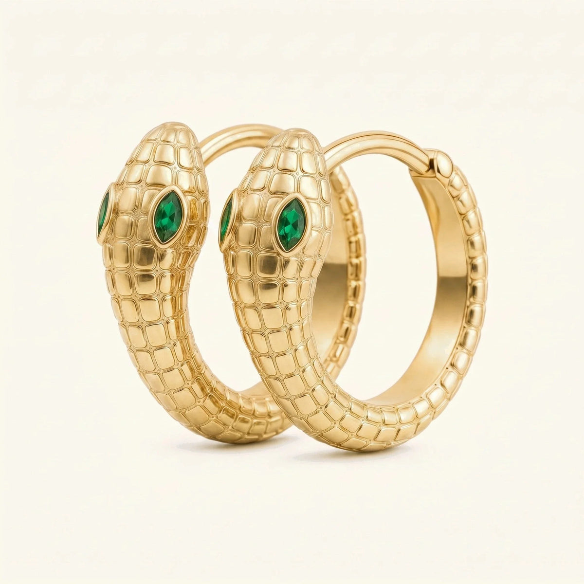 Méhen snake hoop earrings in 18K yellow gold, scaled body coiled into a hoop and marquise emerald eyes