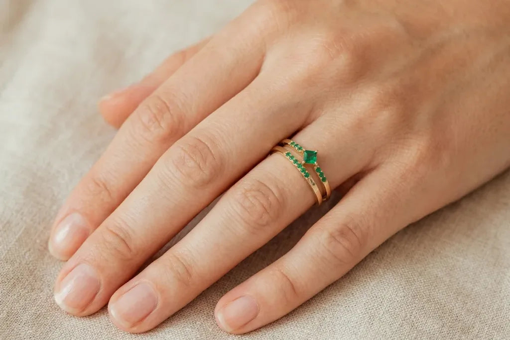 Emerald solitaire ring in 18K yellow gold worn on the finger, showing its look on the hand