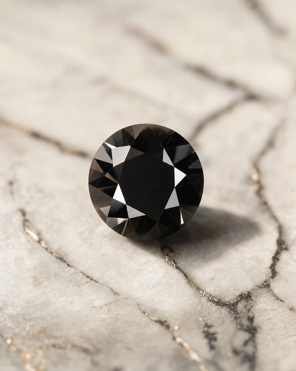 Brilliant cut black diamond resting on light veined marble, high contrast
