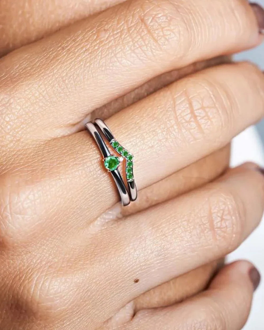Emerald engagement ring worn on the ring finger