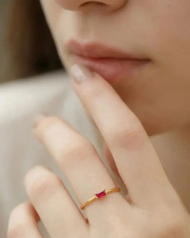 Ruby engagement ring in gold worn on a feminine hand