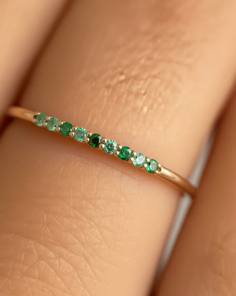 Kiran ring in white gold set with emerald and tsavorite gradient, close-up on green stones