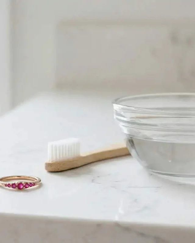 Gently cleaning a ruby ring at home with a brush and soapy water