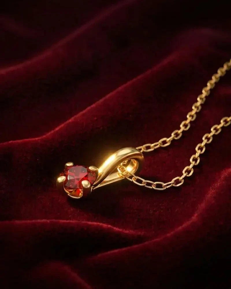 Ruby pendant in 18K yellow gold, claw setting, on red velvet, with a fine gold chain