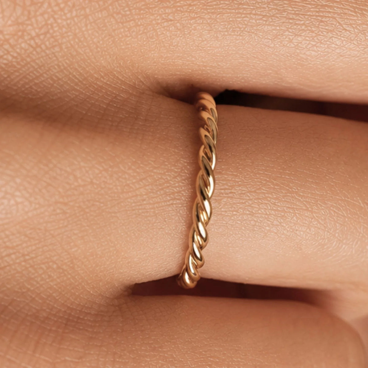 Musubi twisted gold band worn on the finger, fine rope-effect ring