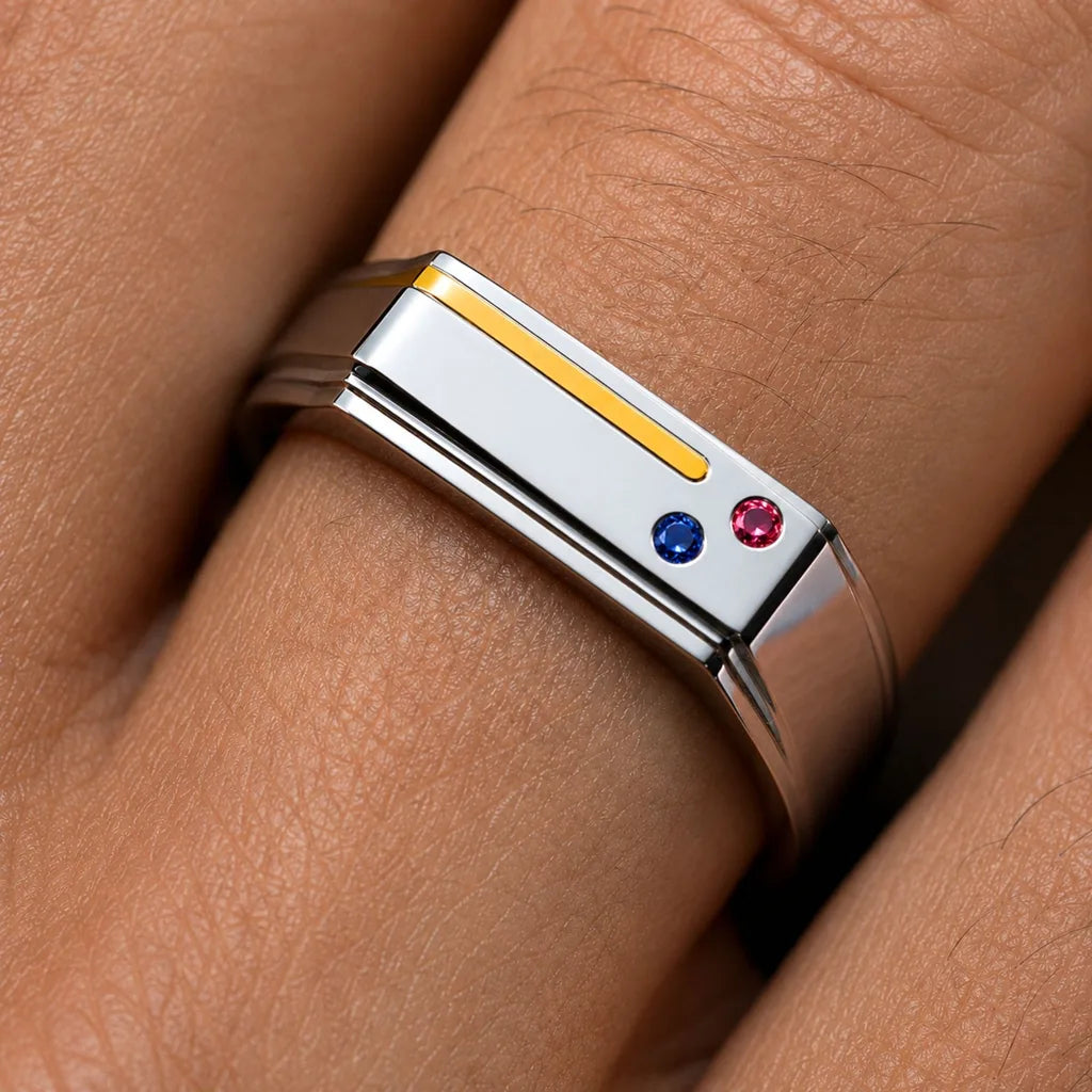 The Essence de Bandor ring in platinum and 18K gold, with an inlaid gold thread and flush-set ruby and sapphire: a two-metal piece receives a hallmark for each metal
