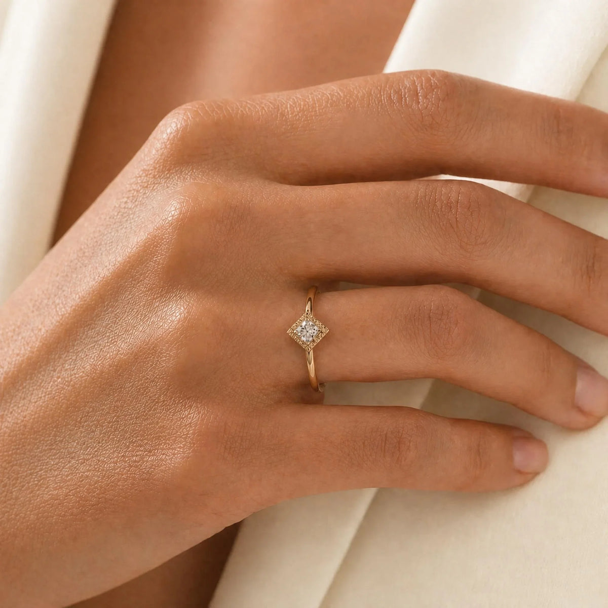 Indrani diamond engagement ring worn on the hand, princess-cut solitaire in twisted rope setting, 18K yellow gold
