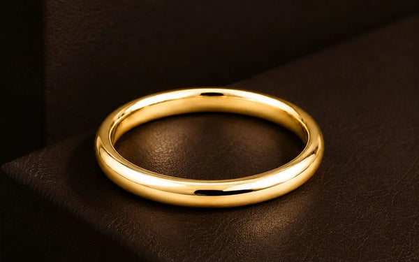 Solid 18K yellow gold wedding ring on dark brown leather, warm light highlighting the gold's brilliance