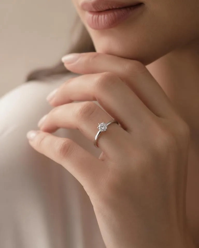 18K white gold diamond solitaire ring worn elegantly on a woman's hand