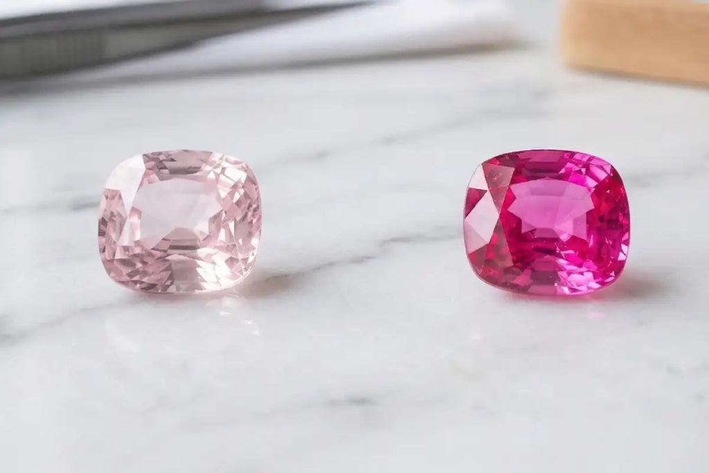 Comparison between a pale pink sapphire and a deep pink sapphire on white marble, showing the full range of hues