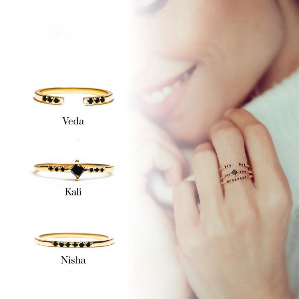 A stack of yellow gold and black diamond rings, a contemporary take on stacking